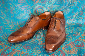 brown male leather shoes on blue background