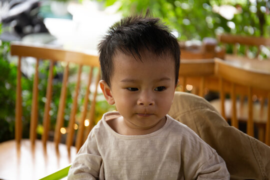 Portrait of Asian boy sit on his chair in the coffee shop