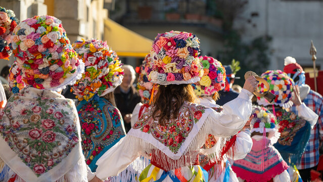 Italian carnival parade. Traditional female costumes from Resia Village. Colorful floral hats. San Pietro al Natisone, Udine province, Friuli Venezia Giulia region, Italy.