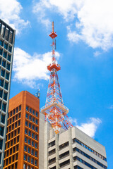 Orange and whit antena ate the top of a building seeing from street level