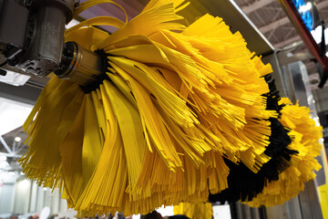 detail of black and yellow automatic car wash system cleaning fiber sponge brushes on spinning...