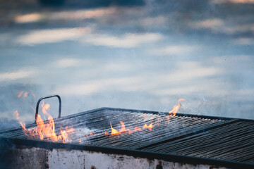 closeup detail of old barbeque grill with fire flames coming out