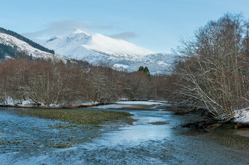 snow-covered mountains and river in the foreground