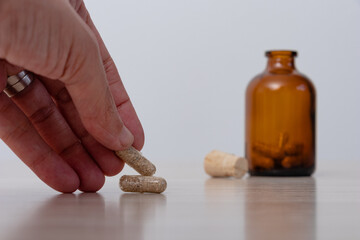 Hand raising psychedelic mushroom capsule pill