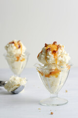 vanilla ice cream with pecans and caramel sauce in glass dish