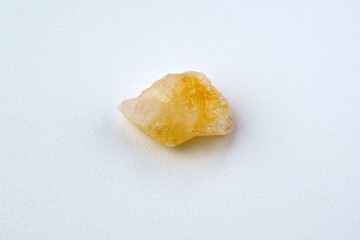 Natural stone of untreated citrine crystal, yellow quartz. Selective focus, white background