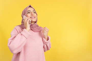 Happy muslim woman celebrating while talking to the mobile