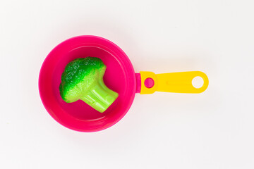 broccoli cabbage in a pan with a spoon and fork on a white background