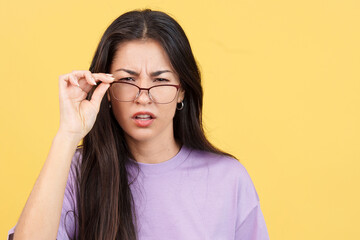 Woman taking off her glasses to see facing the camera