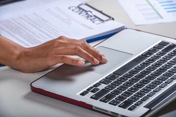 legal adviser reading examine draft contract in notebook and paper