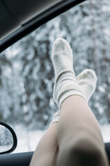 Feet up on the dashboard during a road trip through the snow forest in Nuuksio National Park, Helsinki, Finland