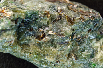 Rock with peridot olivine mineral, black background. Close-up, macro