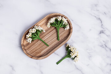 Decorative artificial flowers for creativity on wooden tray. Top view. Decorative bouquets