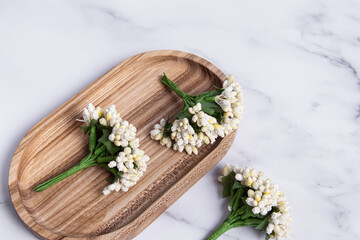Decorative artificial flowers for creativity on wooden tray. Decorative bouquets closeup