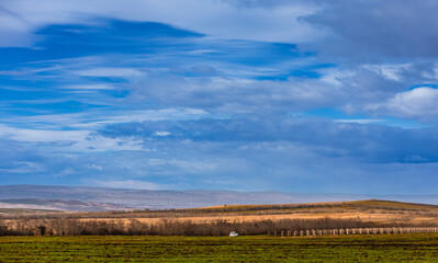 Autumn fall landscape in Kakheti region, Georgia. Beautiful view on fields and vineyards. Dramatic sky. Mountains in the background.