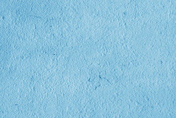 Cracked light blue paint on plaster.