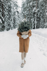 Woman with a Christmas tree in the forest. Christmas and winter concept