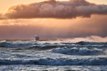 Naklejka na ściany i meble A ship during a storm at sea. A large ferry moves across the sea during a hurricane