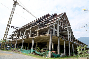 Fototapeta premium CHANTHABURI, THAILAND - FEBRUARY 19, 2023 : The Pavilion of Thai Buddhist temple Construction has not been completed abandoned for a long time with natural background.