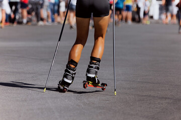 back girl skier roller skiing race on asphalt