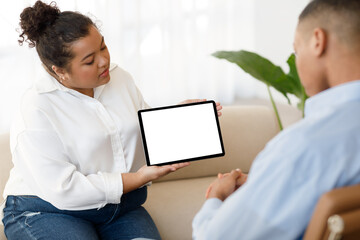 Mixed race woman therapist showing male patient digital tablet, mockup - obrazy, fototapety, plakaty