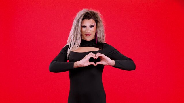 Drag queen man representing a heart in the shape of fingers