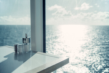 Fototapeta na wymiar Table with salt and pepper pots situated by a large window overlooking the endless sea in sunny weather.