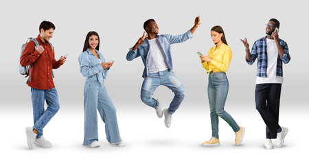 Fototapeta premium Group Of Multiethnic People Using Smartphones While Posing Over White Gradient Background