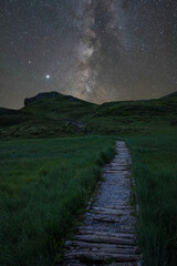 Starry night on the mountain trail: A breathtaking alpine adventure in Switzerland. Milky Way and stars hike on Swiss Alps.