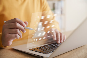 Business performance checklist concept, businessman using laptop doing online checklist survey,...