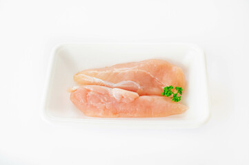 白い背景の食品トレーに入った鶏ささみ