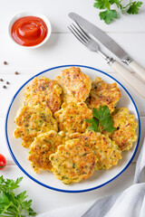 Chicken cutlets made from minced meat, onion, garlic and fresh herbs on a plate on a white wooden background. Top view, selective focus.