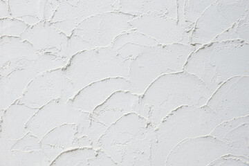 Rough white plaster texture. Textured background of filler paste applied with putty knife in irregular semicircular strokes. Design pattern, wall texture, plaster background