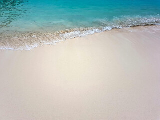 Fototapeta na wymiar Sandy sea coast with waves and turquoise water. High quality photo