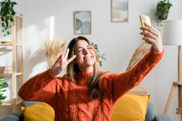 Cheerful woman taking selfie on smartphone