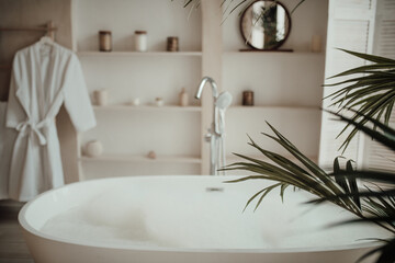 Fototapeta na wymiar Luxury interior of big bathroom at modern african style with oval bathtub in natural lighting