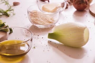 Fennel, grated cheese and oil on a kitchen table