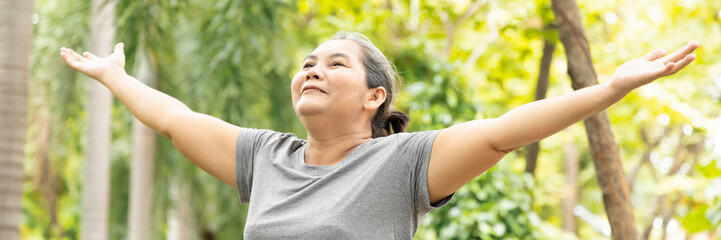 Old senior woman working out in green park, breathing clean air, good and healthy life quality and...