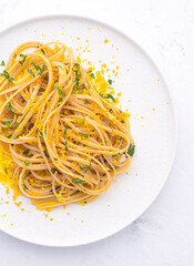 Spaghetti pasta with bottarga (dried tuna or mullet caviar) on a white table. Classic sea dish of...