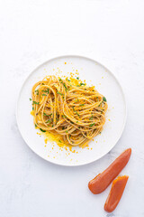 Spaghetti pasta with bottarga (dried tuna or mullet caviar) on a white table. Classic sea dish of Sardinia and Sicilly islands. Italian healthy cuisine
