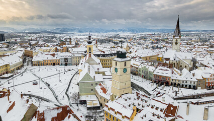 Drone photography of the city center of Sibiu, Romania. Photography was taken from a drone at a lower altitude in winter season with the town hall tower and the big square in the view.