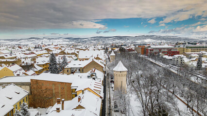 Drone photography of the city center of Sibiu, Romania. Photography was taken from a drone at a lower altitude in winter season with a medieval defensive tower in the view.