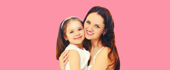 Portrait of happy smiling mother with daughter child on pink background