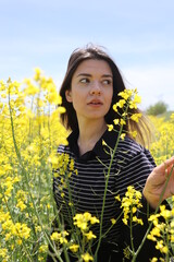 Close up photo of young woman in yellow flower field.