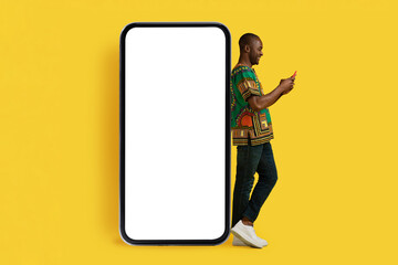 Handsome african man posing next to big cell phone, mockup