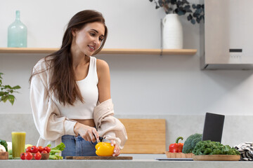 An attractive woman is watching a cooking class on cooking a vegetarian dish. Video recipe