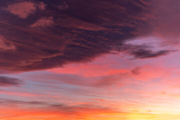 Naklejka na ściany i meble Huge orange cloud in the sky at sunset.