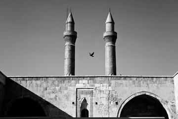 brid fliying between old mosque's minarets - 573308365