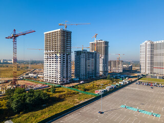 Parking lot and construction site with cranes.