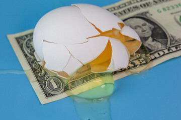 Concept image showing the high price of eggs with a broken egg over a US dollar bill.